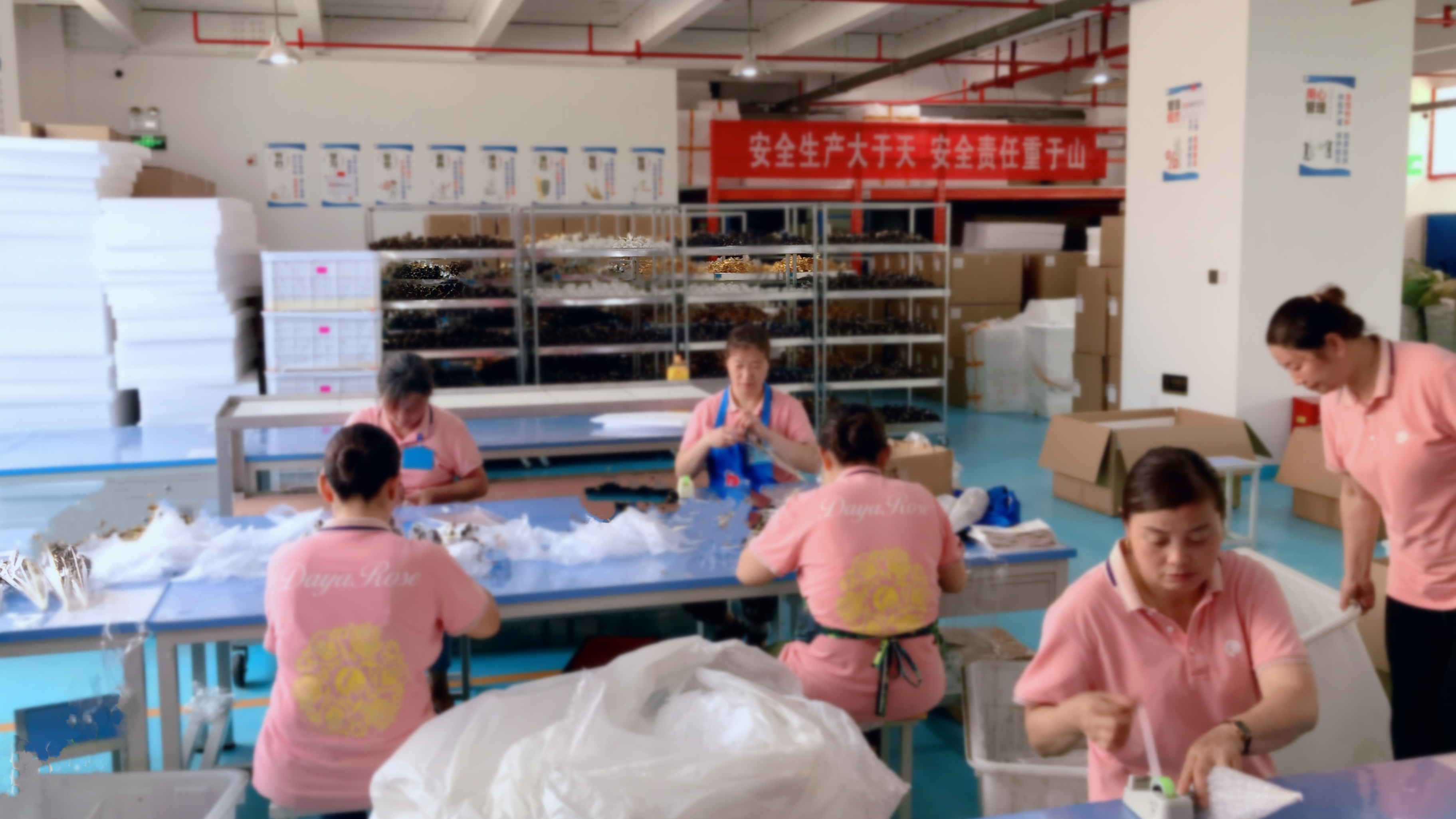 The warehouse partners happily and efficiently pack the customized gold roses for customers
